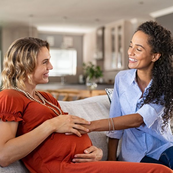 excited-friend-touching-belly-bump-of-pregnant-wom-2023-11-27-04-57-00-utc-min